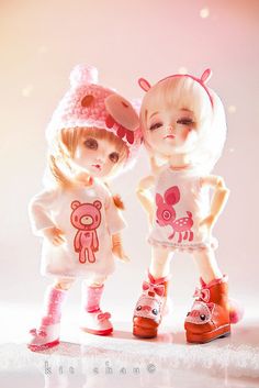 two dolls are standing next to each other