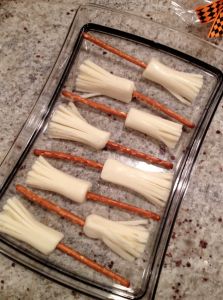 carrots and cheese sticks are arranged on a baking sheet in preparation to be cooked