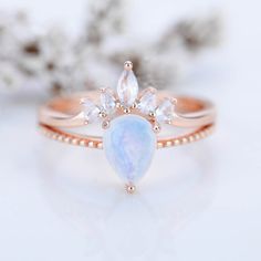 a rose gold ring with an opalite and white topazte in the center