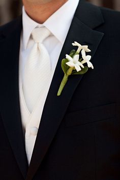 a man in a suit and tie with a boutonniere on his lapel