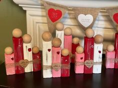 several wooden pegs with hearts on them sitting on a table in front of a fireplace