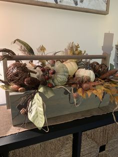 a wooden box filled with lots of different types of fall decorations