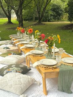 a long table with plates and flowers on it