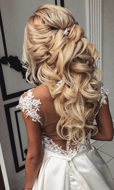 the back of a woman's wedding dress with long blonde hair