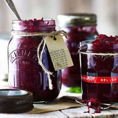 jars filled with jam sitting on top of a wooden table