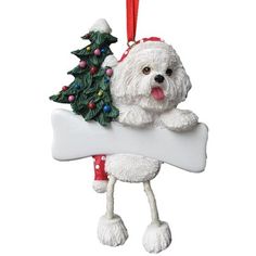 a white dog ornament hanging from a christmas tree with a bone in it's mouth