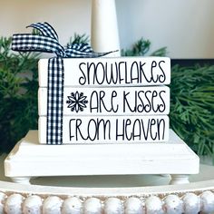 a stack of snowflakes are kisses from heaven wrapped in black and white ribbon