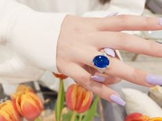 a woman's hand wearing a ring with a blue stone