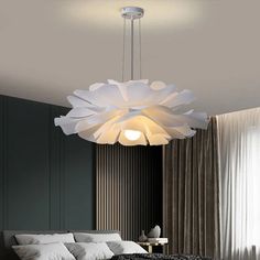 a large white light hanging over a bed