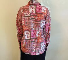 "Gorgeous vintage silk blouse with a beautiful pink & green patchwork design. This soft and flowy silk shirt is fabulous over leggings or tucked into a tight skirt. Button front and cuffs. Size Medium. The model is 5\" 10\" and 135 lbs. 100% Silk. Measures approx. 24\" from armpit to armpit, sleeves measure 22\" long from shoulder seam to cuff, measures 26\" long from top of shoulder to front hem. Excellent condition. No holes or tears." Pink Patchwork Blouse For Spring, Spring Pink Patchwork Blouse, Fitted Pink Patchwork Blouse, Pink Long Sleeve Tops With Floral Patchwork, Fitted Pink Bohemian Blouse, Bohemian Pink Tops With Floral Patchwork, Pink Printed Silk Blouse, Bohemian Pink Printed Blouse, Vintage Pink Patchwork Top