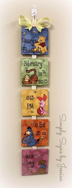 four winnie the pooh books hanging on a wall with ribbon and name tags attached to them