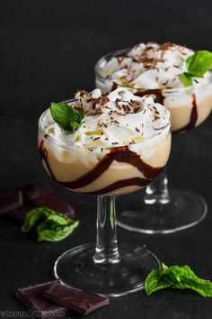 two glasses filled with dessert on top of a table