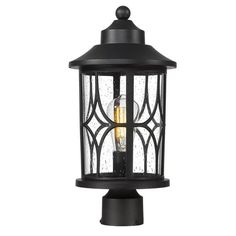 an outdoor post light with a clear glass shade on the top and black metal base