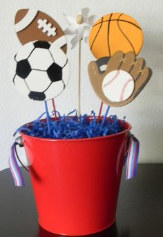 two cupcake toppers in the shape of football, basketball and soccer balls on sticks