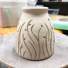 a white vase sitting on top of a wooden table next to other crafting supplies