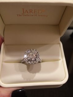 a diamond ring in a box with the lid open to show it's inside