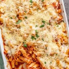 a casserole dish filled with pasta and meat covered in parmesan cheese