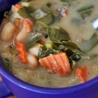 a blue bowl filled with soup and vegetables