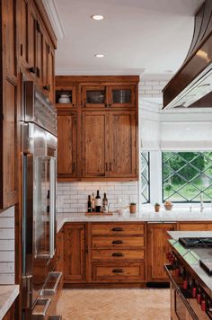 a kitchen with wooden cabinets and marble counter tops