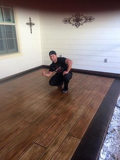 a man kneeling on top of a hard wood floor next to a window and door