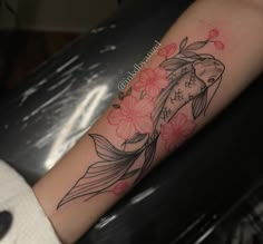 a woman's arm with a koi fish and flowers on it