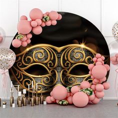 a mask is surrounded by balloons and streamers in front of a backdrop that looks like it has been designed for a masqueradee