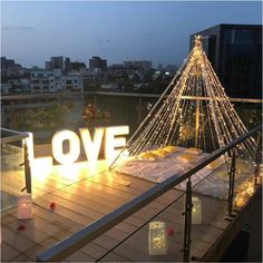 a lighted christmas tree on top of a building with the word love spelled in front