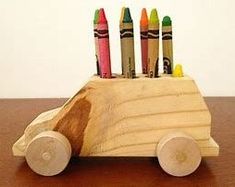 a wooden car with crayons sticking out of it