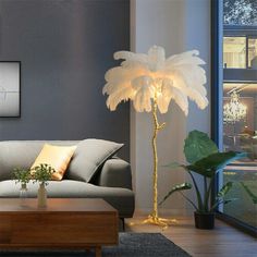 a living room filled with furniture and a tall white feather lamp on top of a coffee table