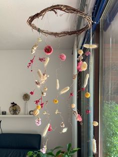 an arrangement of flowers hanging from the ceiling in a living room with a blue couch