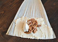 some food is sitting on top of a wooden board with white frosting and nuts