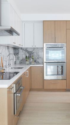 a kitchen with marble counter tops and wooden cabinets