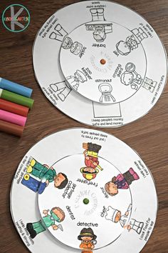 two white paper plates with cartoon characters on them and colored crayons in the background