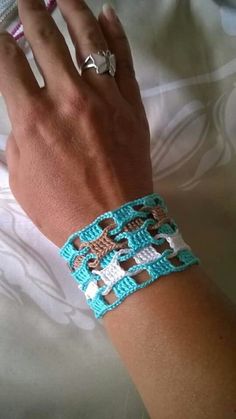 a woman's hand wearing a bracelet with crosses on it