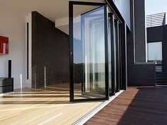 an open door on the side of a building next to a wooden floor and wall