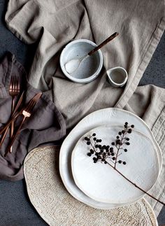 a table setting with plates, utensils and napkins