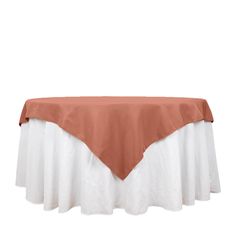 an orange and white table cloth on top of a round table with a brown cover