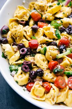 a white bowl filled with pasta salad on top of a table