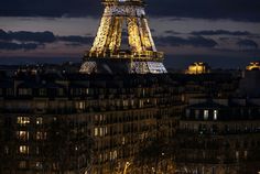 the eiffel tower lit up at night with lights on it's sides