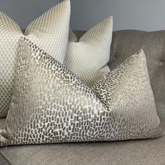 three decorative pillows on a couch in a living room