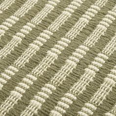 a close up view of a rug with white and green stripes on it's surface