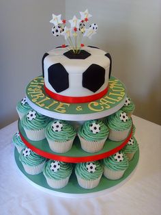 a three tiered cake decorated with cupcakes and a soccer ball on top