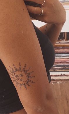 a woman with a sun tattoo on her arm