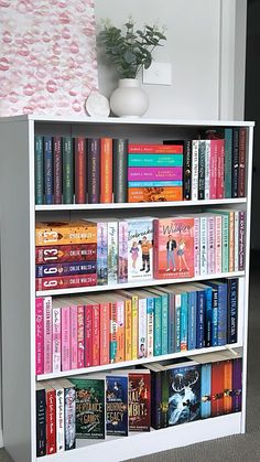 a white book shelf filled with lots of books