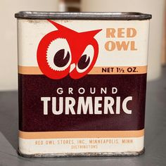 an old red owl ground turmeric can sitting on a table