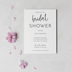 the bridal shower card is surrounded by pink flowers on a white table with petals around it