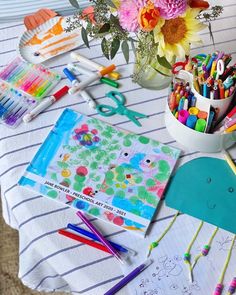 the table is covered with art supplies such as crayons, markers and pencils