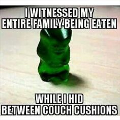 a green gummy bear sitting on top of a wooden table with caption that reads, i witnesses my entire family being eaten while i'd between couch cushions