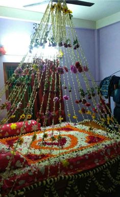 a bed covered in flowers and chains hanging from the ceiling