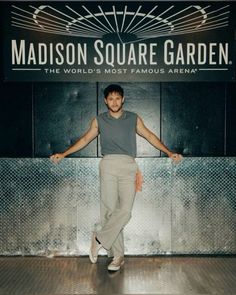 a man standing in front of a sign that says madison square garden the world's most famous arena